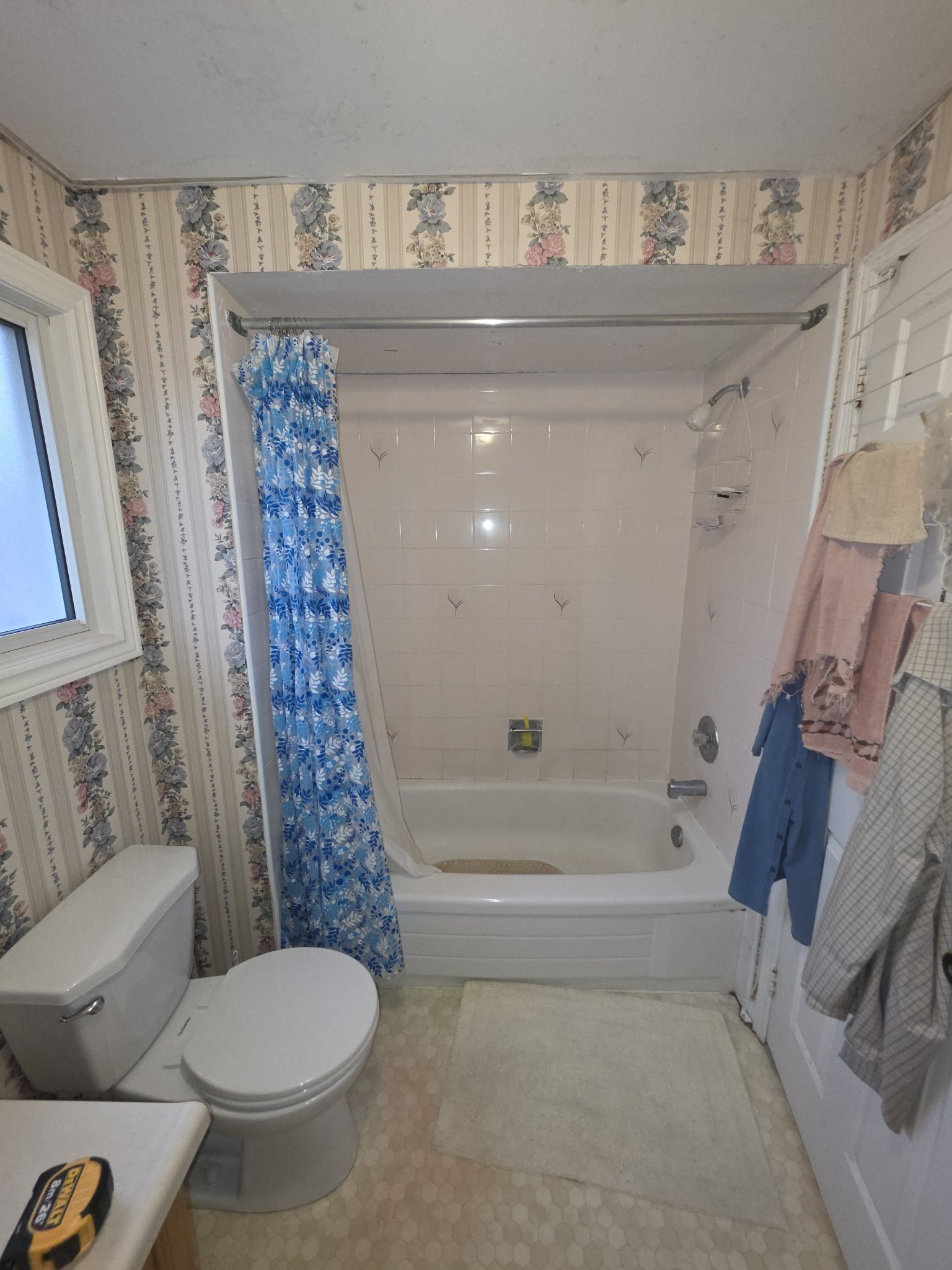 Dated bathroom with floral wallpaper before renovation